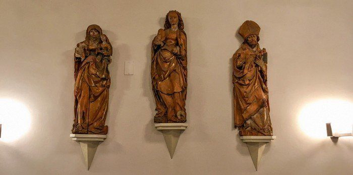 Holzfiguren in der Seitenwand der Dorfkirche Alt-Wittenau mit Anna (die Mutter Marias), Maria (die Mutter Jesu) und Nikolaus von Myra (der frühere Schutzpatron der Dorfkirche)