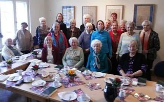 Gruppenbild mit Senioren im Pfarrhaus Waidmannslust vor dem gedeckten Kaffeetisch