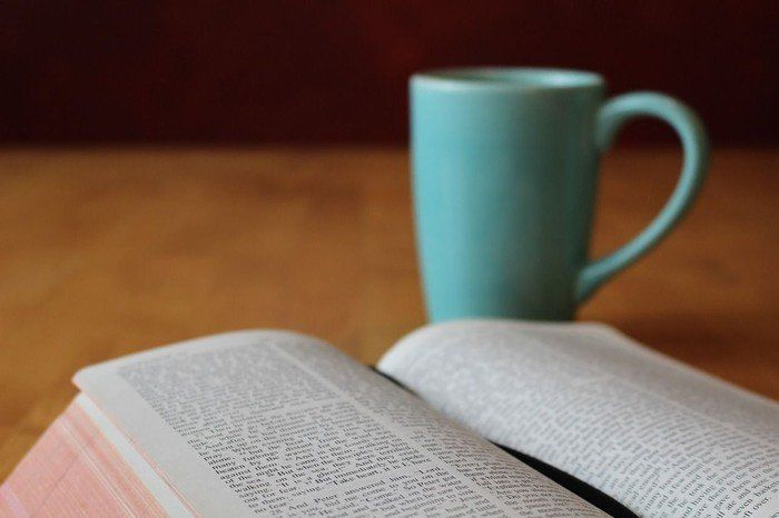 Aufgeschlagene Bibel mit Teebecher